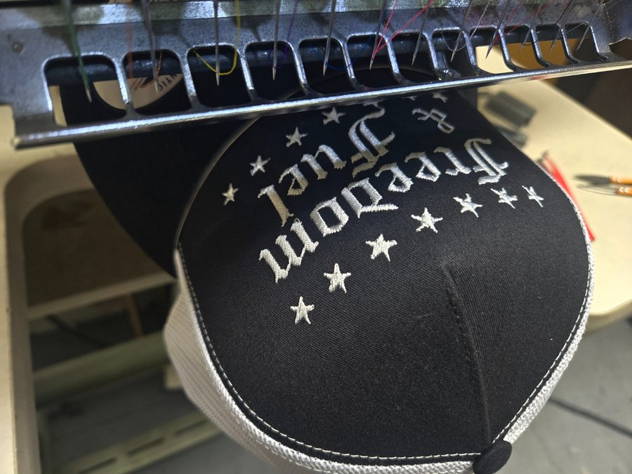 Freedom and Fuel hat being embroidered on the machine