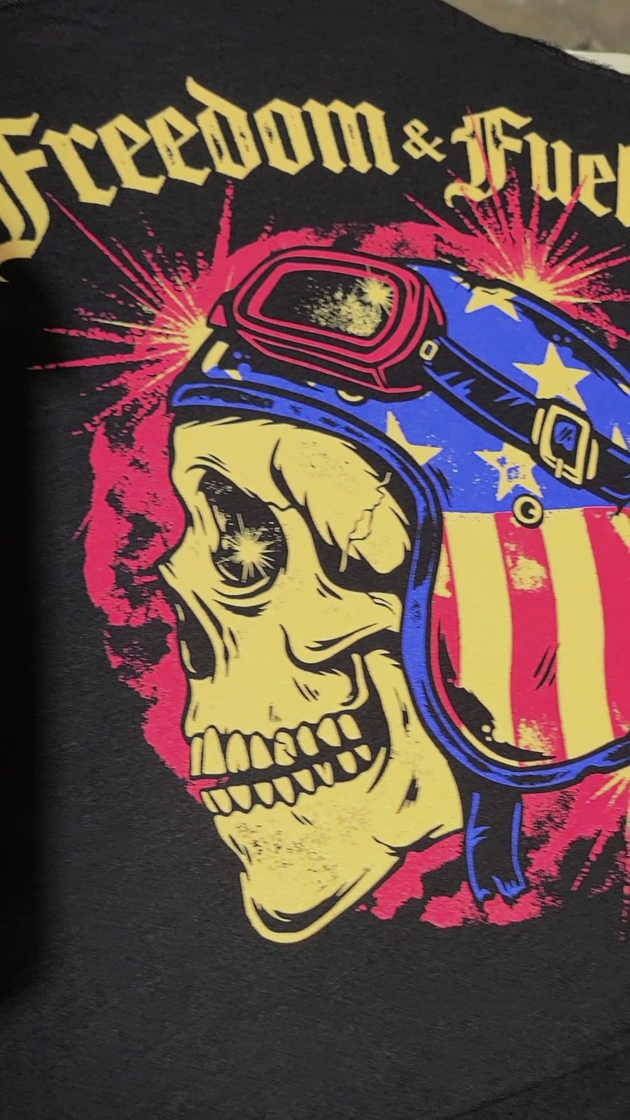 Close-up of a vibrant Freedom and Fuel screen print on a black shirt